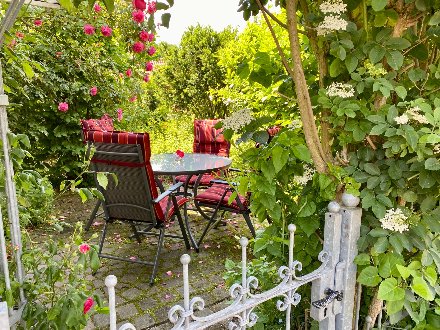 Gartenpforte zur Sitzgruppe mit Rosen
