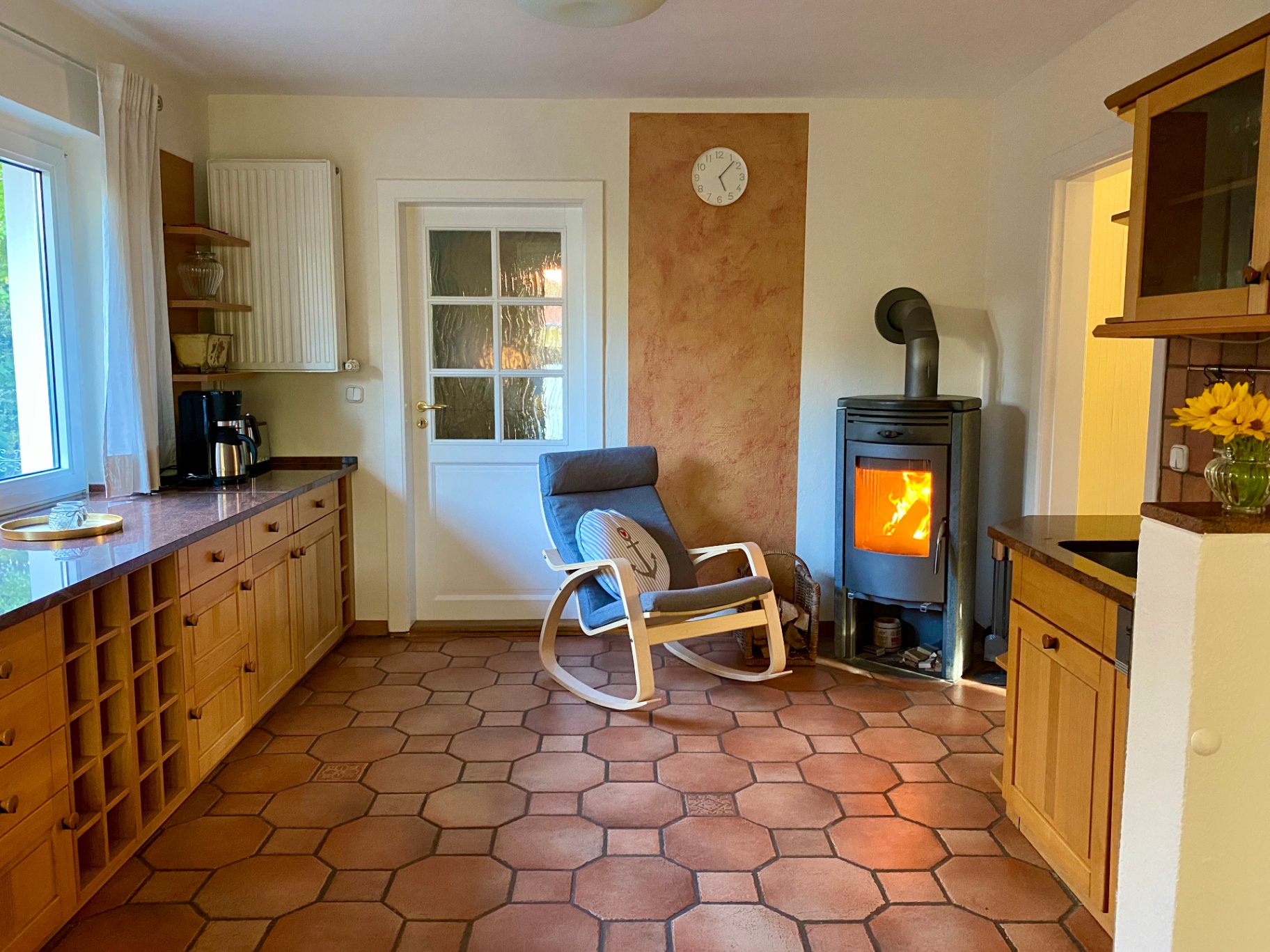 Landhausküche mit Kaminofen und Terrakottafliesen im Ferienhaus