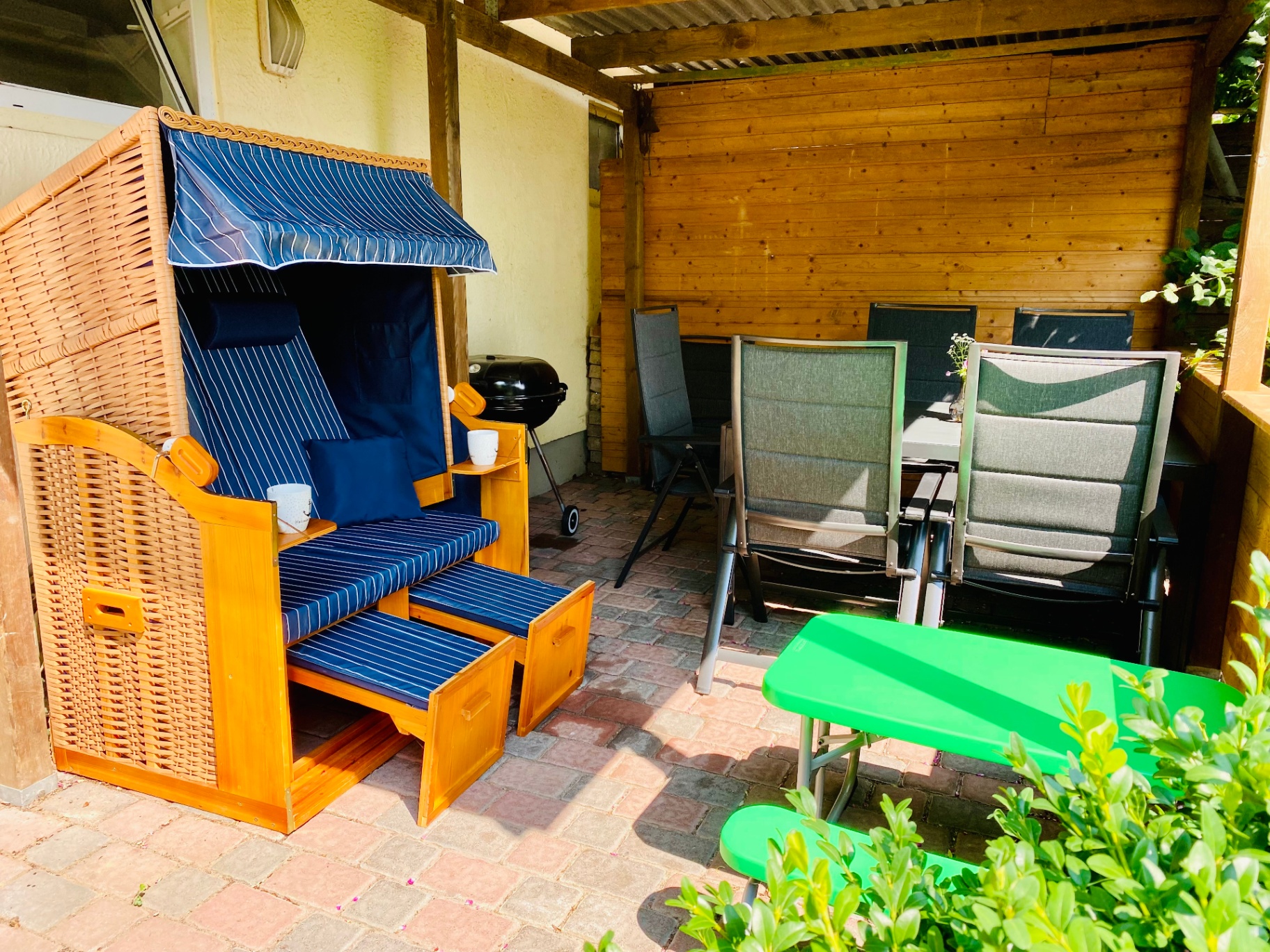 Überdachte Terrasse mit Strandkorb und Grill am Ferienhaus Kuschel-Muschel